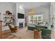 Inviting living room features a fireplace, floating shelves, and a large green couch for cozy relaxation at 11329 Fullerton Place Nw Dr, Huntersville, NC 28078