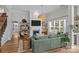 Cozy living room features a fireplace, a large green couch, and direct access to the dining area at 11329 Fullerton Place Nw Dr, Huntersville, NC 28078