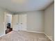 Bedroom featuring neutral walls, carpet, and double doors leading to the closet at 120 Todd Nw Dr, Concord, NC 28025