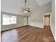 Spacious living room with a vaulted ceiling, a ceiling fan, and stylish wood-look floors creates a welcoming ambiance at 120 Todd Nw Dr, Concord, NC 28025