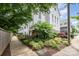Modern townhouse with lush front yard landscaping and a sidewalk along a wooden fence, highlighting architectural details at 1207 E 36Th St, Charlotte, NC 28205