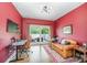 Bright living room featuring red walls, hardwood floors, and access to a balcony at 1207 E 36Th St, Charlotte, NC 28205