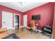 Office area with sleek desk, hardwood floors, and red accent walls at 1207 E 36Th St, Charlotte, NC 28205