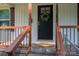 Close up of a home's front door with decorative wreath and stained wood porch railings at 1212 Frank Ext, Rock Hill, SC 29730