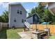 Charming backyard featuring a wooden fence, stone patio with a fire pit, and lush green grass at 12304 Huntersville Concord Rd, Huntersville, NC 28078