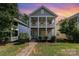 Charming two-story home with double front porches, bright blue door, and lush landscaping at 12304 Huntersville Concord Rd, Huntersville, NC 28078