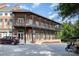 A brick building with a second-story balcony, featuring outdoor seating and classic architectural design at 12304 Huntersville Concord Rd, Huntersville, NC 28078