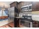 Close-up of the kitchen featuring stainless steel appliances and dark wood cabinetry at 12304 Huntersville Concord Rd, Huntersville, NC 28078