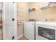 Bright laundry room features a side-by-side washer and dryer and convenient wire shelving for storage at 12304 Huntersville Concord Rd, Huntersville, NC 28078