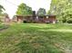 Brick home featuring a spacious backyard with a well-maintained lawn and mature trees at 13617 Lake Bluff Dr, Matthews, NC 28105