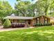 Brick home featuring dark shutters and lush landscaping, offering a classic and inviting curb appeal at 13617 Lake Bluff Dr, Matthews, NC 28105