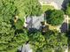 A gorgeous aerial view of a neighborhood home featuring a dark grey roof, surrounded by mature trees at 15400 Groveland St, Huntersville, NC 28078