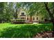 Spacious backyard with green grass, mature trees, brick patios and covered porch at 15400 Groveland St, Huntersville, NC 28078