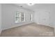 Carpeted bedroom featuring two windows, a ceiling fan, and neutral paint at 15400 Groveland St, Huntersville, NC 28078