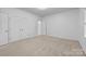 Carpeted bedroom featuring double doors and a large window at 15400 Groveland St, Huntersville, NC 28078