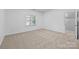 Carpeted bedroom featuring a large window and neutral paint at 15400 Groveland St, Huntersville, NC 28078