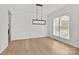 Bright empty dining room with hardwood floors, modern light fixture, and large window with bright light at 15400 Groveland St, Huntersville, NC 28078