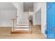 Bright foyer with hardwood floors, a staircase with wood banister, and a view into other rooms at 15400 Groveland St, Huntersville, NC 28078