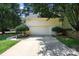 A two-car garage with a concrete driveway, complemented by manicured greenery and a well-maintained exterior at 15400 Groveland St, Huntersville, NC 28078
