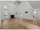 Bright empty living room featuring a fireplace, ceiling fan, and hardwood floors, with bright light at 15400 Groveland St, Huntersville, NC 28078