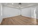Bright main bedroom featuring wood floors, a tray ceiling, and neutral paint at 15400 Groveland St, Huntersville, NC 28078