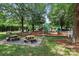 A well-maintained community playground featuring picnic tables, mulch ground cover, and mature shade trees at 15400 Groveland St, Huntersville, NC 28078