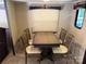 The dining area has a table set with four chairs and neutral carpet at 155 Indian Harbor Trl # E243, Mount Gilead, NC 27306