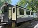 RV with outdoor seating, supported by brick blocks and nestled in a wooded area at 155 Indian Harbor Trl # E243, Mount Gilead, NC 27306