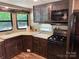 Well-equipped kitchen with dark cabinets, countertops, and stainless steel appliances at 155 Indian Harbor Trl # E243, Mount Gilead, NC 27306