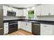 Bright kitchen featuring white cabinets, stainless steel appliances, and dark countertops at 1837 6Th Nw Ave, Hickory, NC 28601