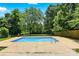 A backyard featuring a pool with concrete surrounding lush greenery and foliage at 1837 6Th Nw Ave, Hickory, NC 28601