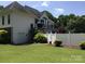 Serene backyard featuring a white fence, mature trees, and a glimpse of the home's architecture at 1842 Caroline Way, Fort Mill, SC 29715