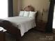 A well-lit bedroom with wood furniture and a queen bed with beautiful wood flooring at 1842 Caroline Way, Fort Mill, SC 29715