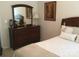 A neat bedroom with a dresser, mirror and queen-sized bed with neutral colored bedding at 1842 Caroline Way, Fort Mill, SC 29715