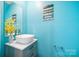 Stylish half-bathroom with vessel sink, grey vanity, and bright blue walls at 2011 Valdosta Way, Charlotte, NC 28215