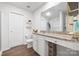A bathroom featuring a granite countertop vanity, white cabinets, and wood-look flooring at 2011 Valdosta Way, Charlotte, NC 28215