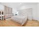 A bright main bedroom with modern headboard and wood floors at 2011 Valdosta Way, Charlotte, NC 28215