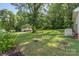 The backyard features a large grass lawn with mature trees and green surroundings at 202 Glenn Ave, Kannapolis, NC 28081