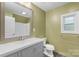 A bathroom features a gray vanity, large mirror, and a shower and toilet at 202 Glenn Ave, Kannapolis, NC 28081