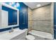 Modern bathroom with blue walls, white vanity, with tiled shower and tub at 202 Glenn Ave, Kannapolis, NC 28081