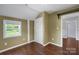A bright bedroom features hardwood floors, a window, closet, and light green paint at 202 Glenn Ave, Kannapolis, NC 28081