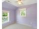 A purple bedroom features wood floors, two windows, and built in shelves at 202 Glenn Ave, Kannapolis, NC 28081