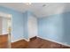 A blue bedroom features hardwood floors and a closet with a view to another room at 202 Glenn Ave, Kannapolis, NC 28081