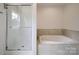 Bright bathroom featuring a soaking tub with tile surround and glass enclosed shower, creating a spa-like atmosphere at 236 Paradise Dr, Belmont, NC 28012