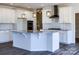 Bright kitchen showcasing an island with granite countertops, white cabinetry, and modern appliances at 236 Paradise Dr, Belmont, NC 28012