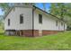 Back exterior of home featuring white siding, brick foundation, and well-kept backyard at 240 Swink Ave, Salisbury, NC 28147