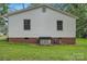 Back exterior view of home with white siding, brick foundation, and green grass at 240 Swink Ave, Salisbury, NC 28147