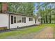 Exterior view of home with white siding, black shutters, brick foundation, and green grass at 240 Swink Ave, Salisbury, NC 28147