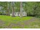Landscaped front yard with mature trees surrounding the charming white home at 240 Swink Ave, Salisbury, NC 28147