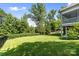 Lush backyard features a well-maintained lawn, mature trees, and privacy provided by manicured hedges at 2501 Christenbury Hall Nw Ct, Concord, NC 28027